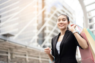 Young woman using phone while standing in city