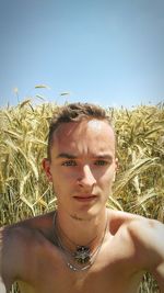 Portrait of young shirtless man against clear sky