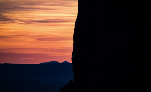 Scenic view of silhouette mountain against orange sky