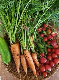 Freshly harvested vegetables in woven basket on wooden table