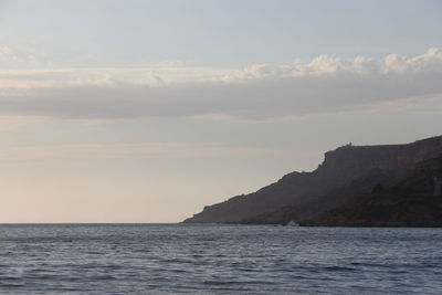 Scenic view of sea and mountains against sky