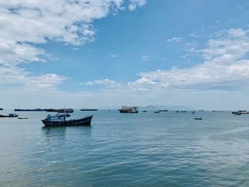 Fishing boats in sea against sky