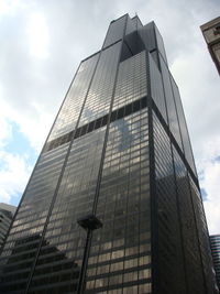 Low angle view of glass building against sky