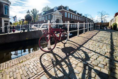 Bicycles on footpath by street against buildings in city