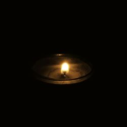 Close-up of illuminated lamp over black background