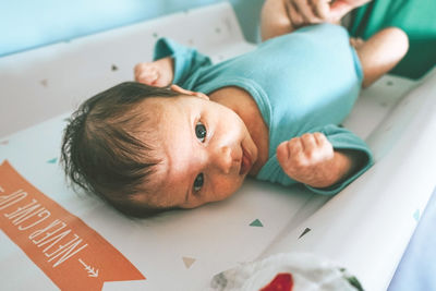 High angle portrait of baby lying on table at home