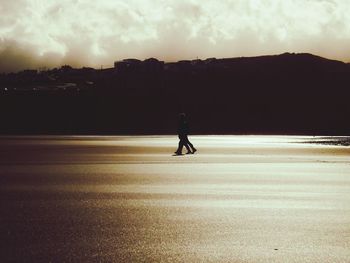 Silhouette of man on road against sky