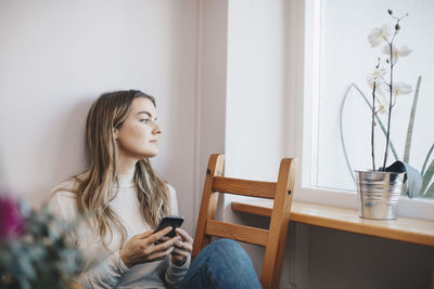 Young woman using mobile phone at home