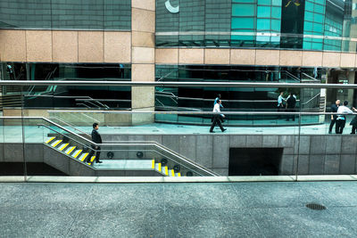 People walking on staircase of modern building