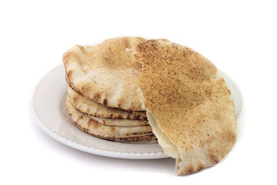 Close-up of bread in plate against white background