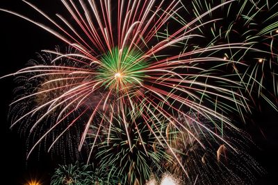 Low angle view of firework display at night