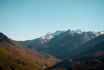 Scenic view of snowcapped mountains against clear blue sky