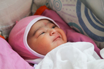 Portrait of cute new born baby girl in pink outfit.... in playful mood