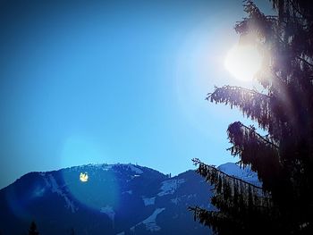 Low angle view of tree mountain against clear blue sky