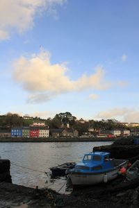 Boats moored on sea against sky in city