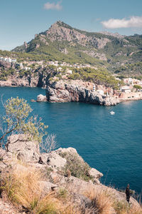 Scenic view of lake by mountains against sky