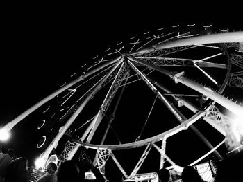 Low angle view of illuminated ferris wheel against sky at night