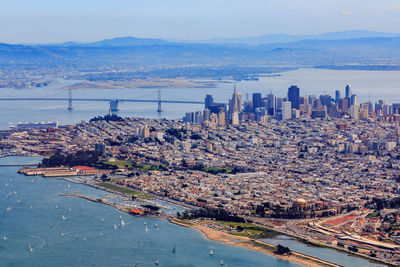 High angle view of city by sea against sky