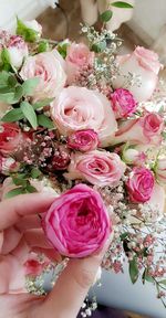 Close-up of hand holding rose bouquet