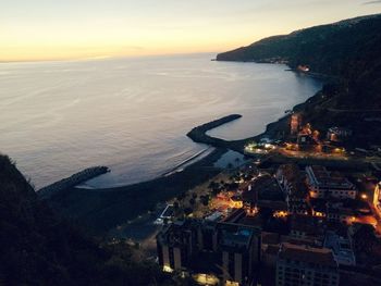 High angle view of city at seaside during sunset