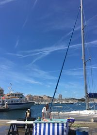 Sailboats in sea against blue sky