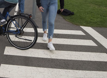 Low section of person with bicycle on road