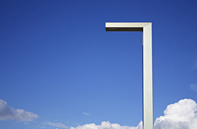 Low angle view of street light against blue sky