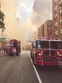 Cars on road in city against sky