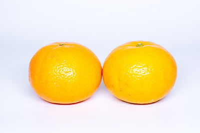 Close-up of orange fruit against white background