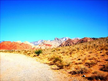 Scenic view of desert against clear blue sky