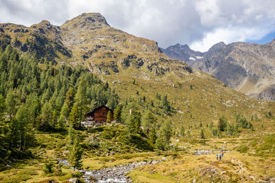 Scenic view of mountains against sky with mountain  hut