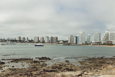 Sea and cityscape against sky