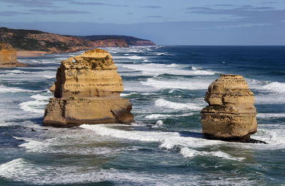 Rock formation on sea shore against sky