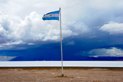 Flag on beach against sky