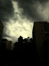 Low angle view of buildings against cloudy sky