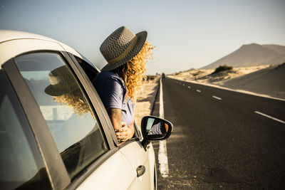 Side view of woman sitting in car