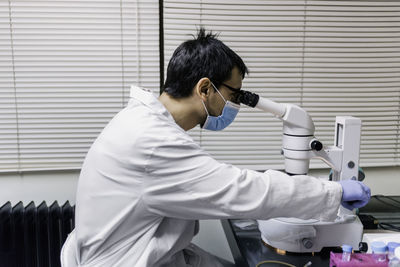 Male scientist using microscopy in laboratory