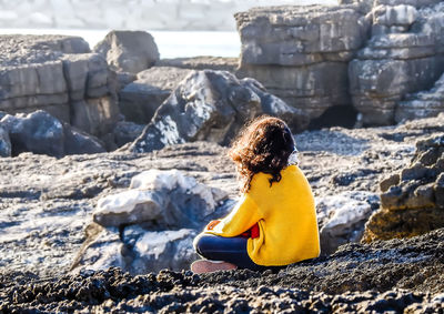 Woman sitting on rock