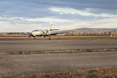 Abandoned airplane parked on runway against sky