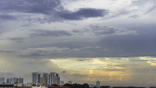 View of cityscape against cloudy sky