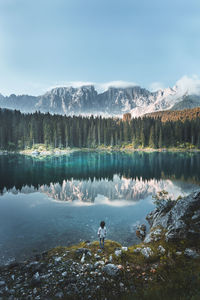 Man standing by lake against sky