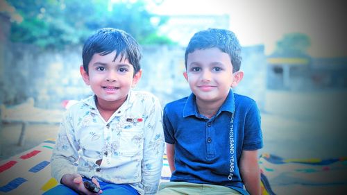 Portrait of smiling boy sitting outdoors