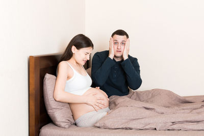 Young couple sitting on bed