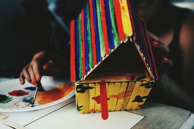 Cropped image of woman painting toy house