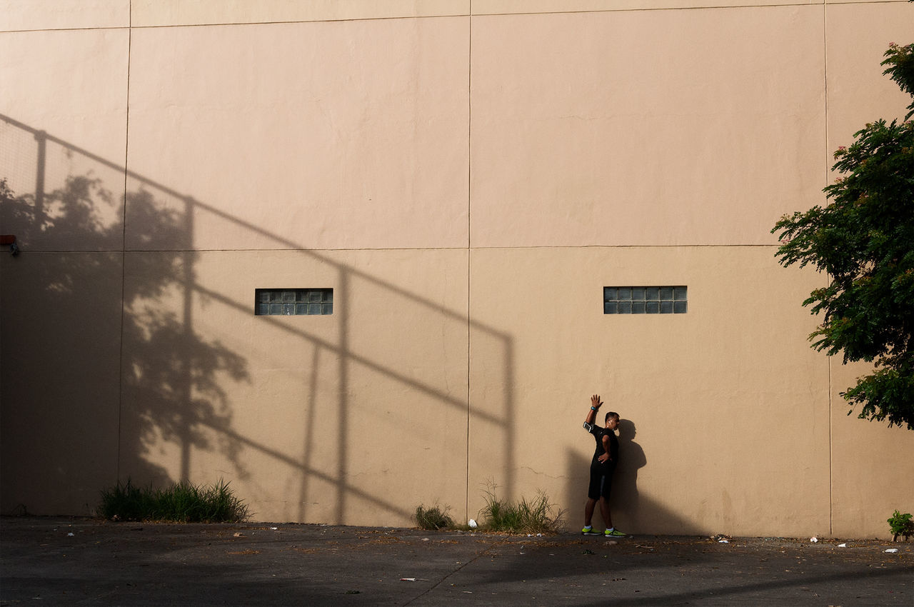 REAR VIEW OF MAN WALKING IN TOWN