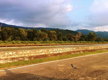 Road by lake against sky