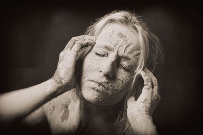 High angle view of young woman covered with mud