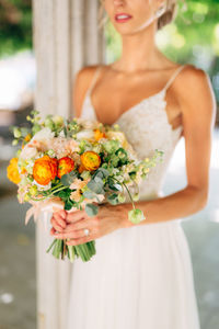 Midsection of woman holding flower bouquet