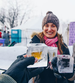 Friends toasting drinks while standing outdoors during winter