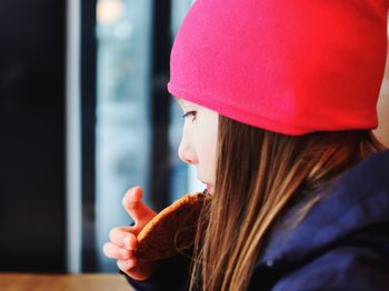 Close-up of girl eating cookie at home